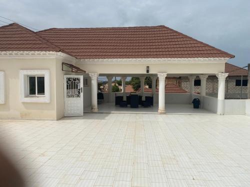 a house with a patio and a roof at Muhammed Ceesay Villa in Old Yundum