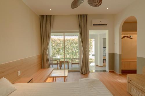 a bedroom with a bed and a dining room at Tây Tiến Bungalow in Phu Quoc