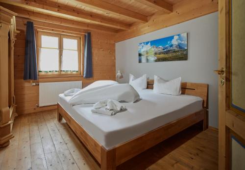ein Schlafzimmer mit einem großen Bett in einem Holzzimmer in der Unterkunft Brabander Hütte in Gaschurn