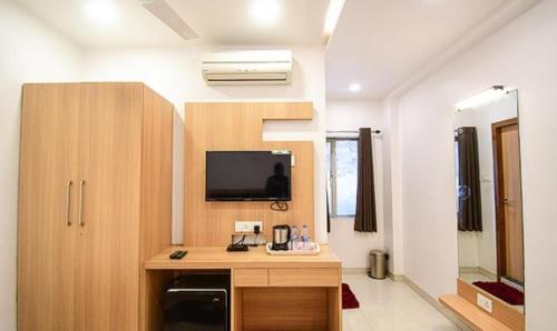 a room with a desk and a tv in a room at FabHotel Stay Inn International - Nr Sealdah Station in Kolkata