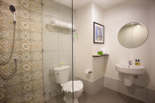 a bathroom with a shower and a toilet and a sink at Recenta Phuket Suanluang in Phuket
