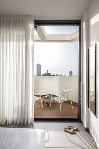 a room with a balcony with a table and chairs at Mate GEORGE - By HOMY in Tel Aviv