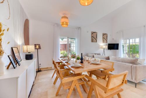 uma sala de estar com uma mesa de madeira e cadeiras em VACATION MARBELLA I Villa Faldo, Golf Valley, Private Pool, 24H Security, 10 min from the Marina em Marbella