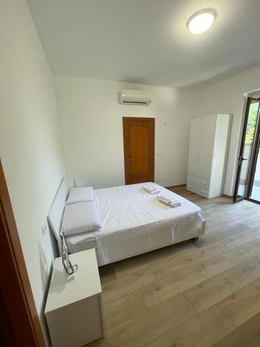 a bedroom with a white bed and a wooden floor at Dal barone in Capo dʼOrlando