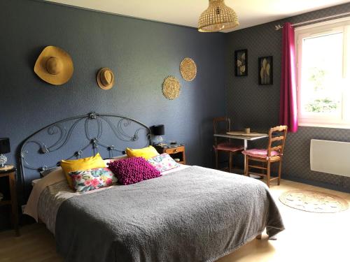 Un dormitorio con una cama con almohadas de colores. en Le Domaine d'Olène, en Le Pin