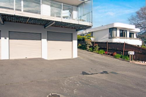 a house with two garage doors in a driveway at Seaside Sounds - Picton Upstairs Unit in Picton