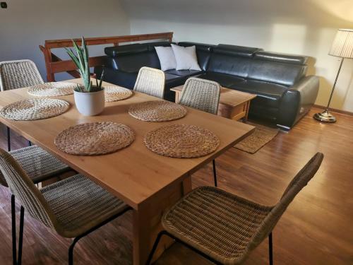 einen Tisch mit Stühlen und ein Sofa im Wohnzimmer in der Unterkunft Apartamenty no3 in Paczków