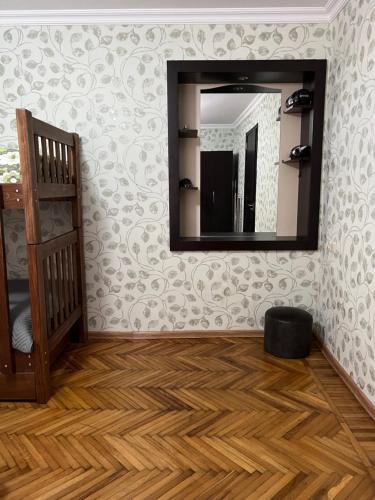 ein Raum mit einem Spiegel und einem Holzboden in der Unterkunft Marine Residence in Batumi
