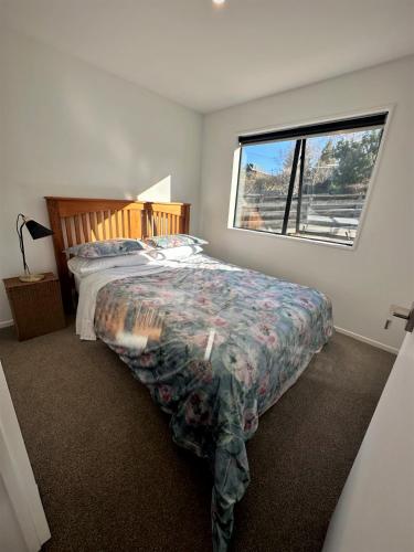 a bedroom with a bed and a window at Naseby Modern Home in Naseby