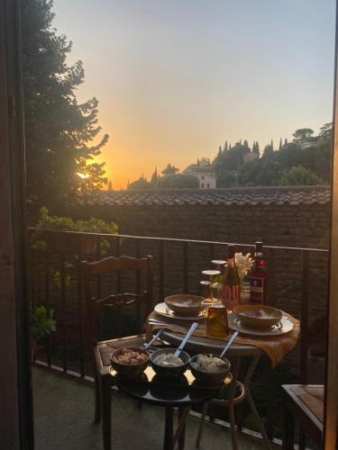 einen Tisch mit Schalen und Teller mit Speisen auf dem Balkon in der Unterkunft Camera Suite Romantica con Giardino in Dimora Storica - B&B Palazzo Robicci in Castiglion Fiorentino