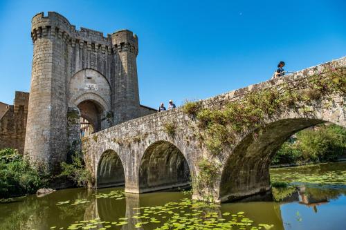 a bridge over a river with people standing on it at Gite Bin Benaise sans linge in Pamproux