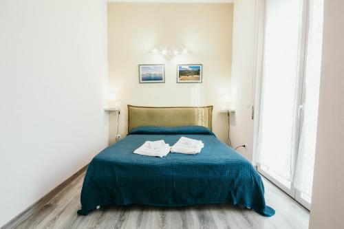 una camera da letto con un letto blu e asciugamani di AL 13 VERDE - Lakeside Leisure & Business a Stresa