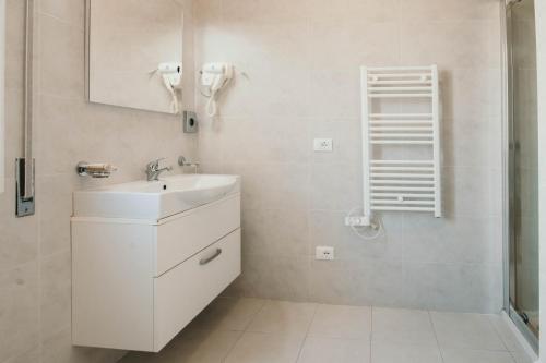 bagno bianco con lavandino e specchio di AL 13 VERDE - Lakeside Leisure & Business a Stresa