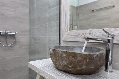 y baño con lavabo de piedra y ducha. en Villa John's Skopelos Stafilos, en Skopelos Town