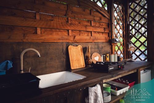 a kitchen with a sink and a wooden wall at Glamping Komarno in Jelenia Góra