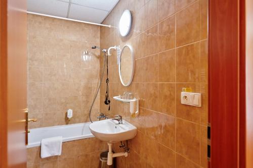 a bathroom with a sink and a mirror and a shower at Hotel Zlatá Hvězda in Vimperk