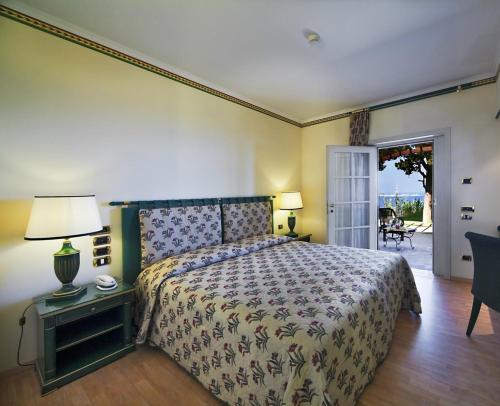 a bedroom with a bed and a table with a lamp at ALTAFIUMARA ISOLE 4* in Cannitello