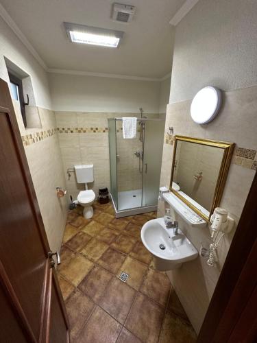 a bathroom with a sink and a toilet and a mirror at Casa Maria Arges in Piteşti