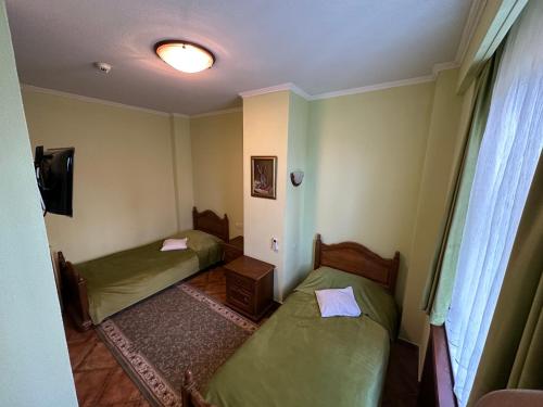a room with two beds and a tv in it at Casa Maria Arges in Piteşti