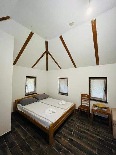 a bedroom with a large bed in a room with wooden ceilings at Studio Apartment in Bihać