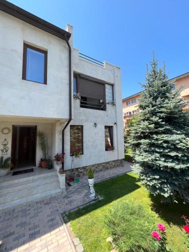 ein Haus mit einem Weihnachtsbaum im Garten in der Unterkunft Vila AlMare in Eforie Nord