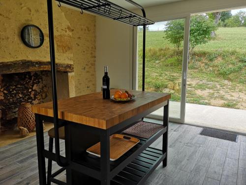 uma mesa com uma garrafa de vinho e uma taça de fruta em Domaine de Lascaux em Montignac