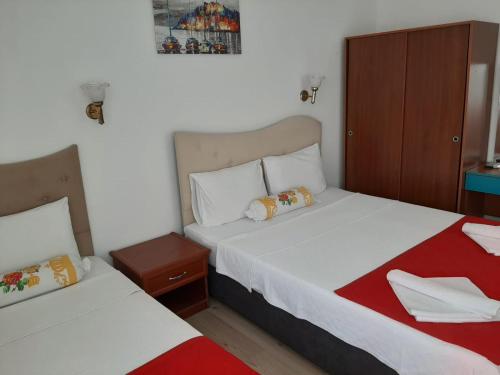 a bedroom with two beds and a night stand at Sevo Hotel in Ayvalık