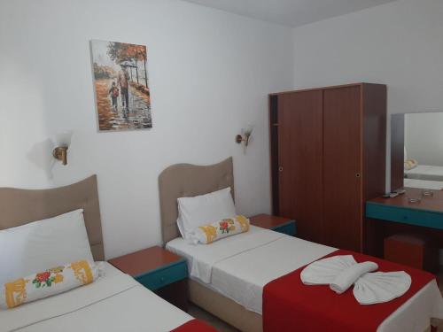 a small bedroom with two beds and a mirror at Sevo Hotel in Ayvalık