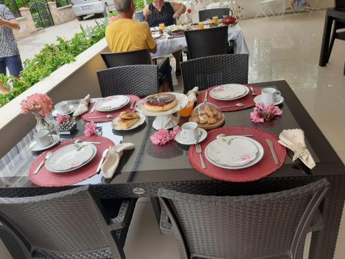 a table with red and white plates and food on it at Sevo Hotel in Ayvalık