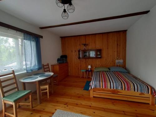 Schlafzimmer mit einem Bett, einem Tisch und Stühlen in der Unterkunft Widny Jaś zaprasza na pięciobój równoczesny in Sulęczyno