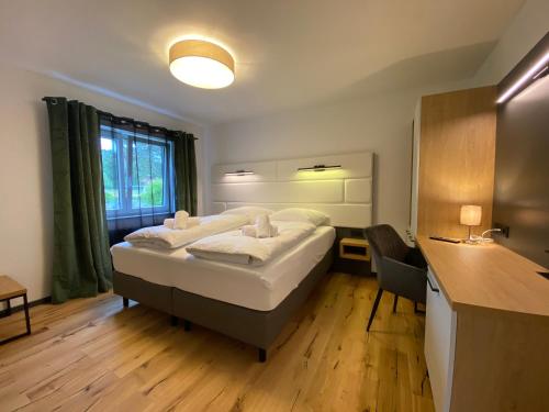a bedroom with a large bed and a desk with a chair at Uraha Apartments in Herzogenaurach