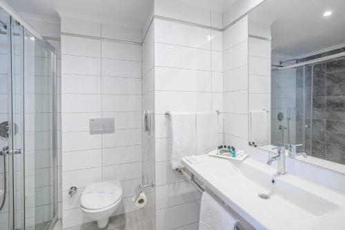 ein weißes Bad mit einem Waschbecken und einem WC in der Unterkunft Avena Resort & Spa Hotel in Alanya