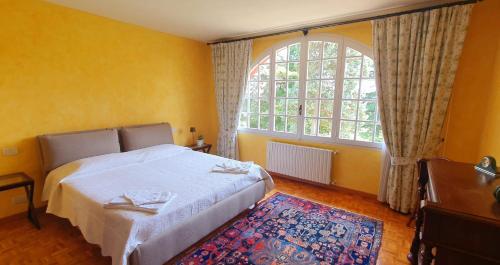 a bedroom with a bed and a large window at La Mondianese "House of Ruchè" in Montemagno