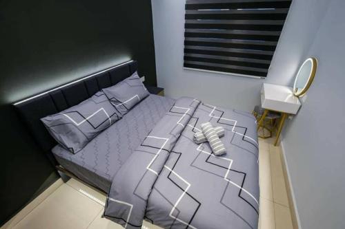 a bedroom with a large bed with gray sheets and pillows at JOVIAL PREMIUM DREAMHOUSE 4ROOM 8PAX@NEAR ICONCITY in Bukit Mertajam