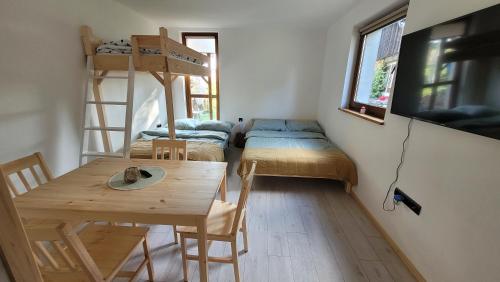 a room with two bunk beds and a table at Apartament na Kasztanowej in Piotrowice