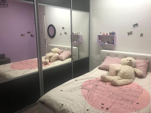 2 ours en peluche assis sur un lit dans une chambre dans l'établissement une maison rien que pour vous avec piscine chauffée, à Mouguerre