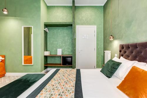 ローマにあるRipetta Executive Suitesの緑の壁、ベッド付きのベッドルーム1室