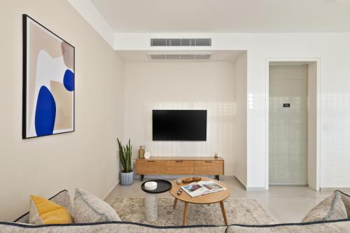 a living room with a couch and a tv at Mate TLV PORT - By HOMY in Tel Aviv