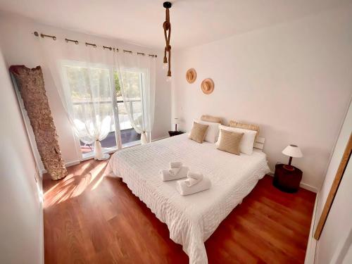 a bedroom with a bed with two trays on it at Zambujeira Terrace in Zambujeira do Mar