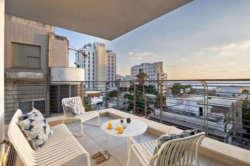 a balcony with chairs and a table on a building at Mate TLV PORT - By HOMY in Tel Aviv