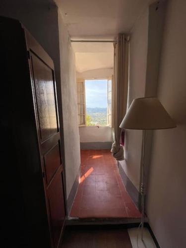 un couloir avec une chambre dotée d'une fenêtre et d'une lampe dans l'établissement Location vacances en Corse, à Oletta