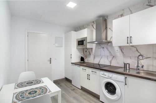 een witte keuken met een wastafel en een wasmachine bij The Greey's House C in Telde