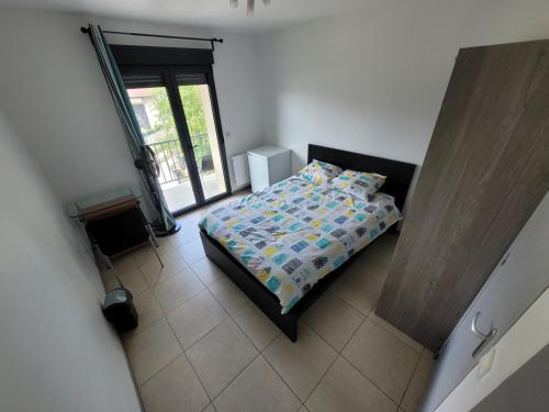 a small bedroom with a bed and a window at Résidence de la gare, chambre meublée in Longjumeau