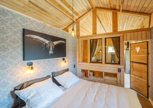 a bedroom with a large bed with a wooden ceiling at Le chalet de pépère in Stavelot
