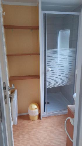 La salle de bains est pourvue d'une douche à l'italienne et d'une porte en verre. dans l'établissement Mobil home Aluna Vacances camping Sunêlia, à Ruoms