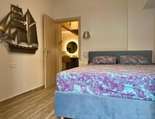 a bedroom with a blue bed with a purple blanket at Loutraki apARTment in Loutraki