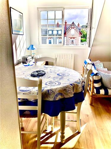 - une table dans une chambre avec fenêtre dans l'établissement L'Appartement de la Plage, à Saint-Quay-Portrieux