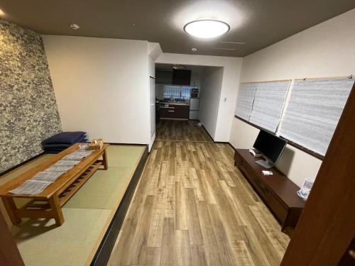 a room with a couch and a table and a television at ABC accommodation in Osaka