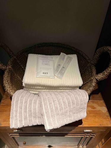 a basket with three towels on a table at Kuon 一棟貸し(素泊まり)北欧サウナ＋ガーデン付き古民家 in Kisa