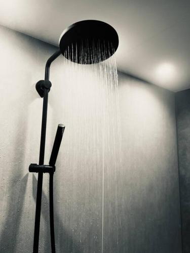 a shower head with water coming out of it at Kuon 一棟貸し(素泊まり)北欧サウナ＋ガーデン付き古民家 in Kisa